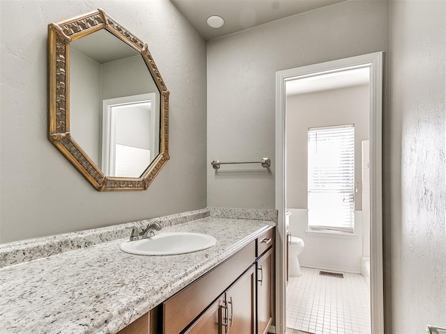 bathroom featuring tile patterned floors, vanity, and toilet