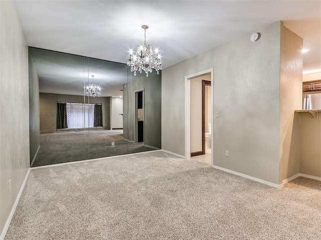 empty room with light carpet and a notable chandelier