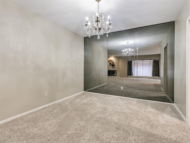 carpeted empty room with a brick fireplace and an inviting chandelier