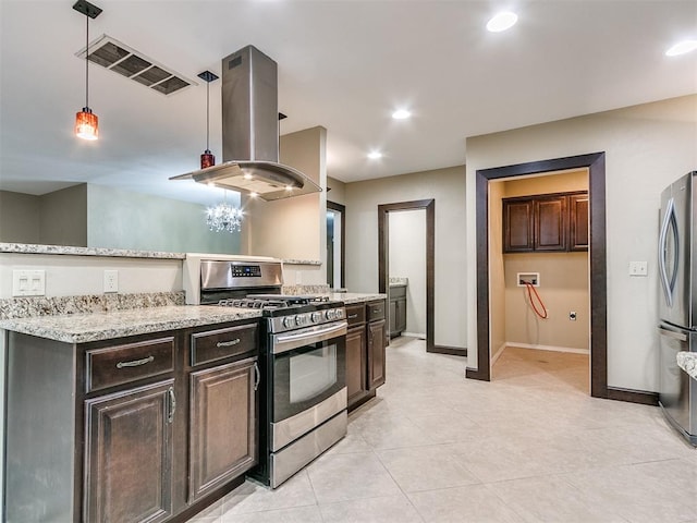 kitchen featuring pendant lighting, light stone countertops, appliances with stainless steel finishes, dark brown cabinets, and island range hood