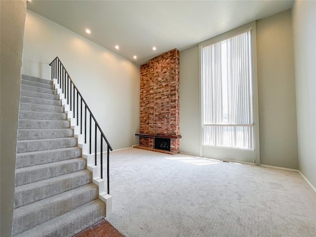 unfurnished living room with carpet flooring and a fireplace