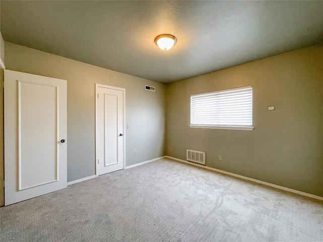 unfurnished bedroom with light carpet and a closet