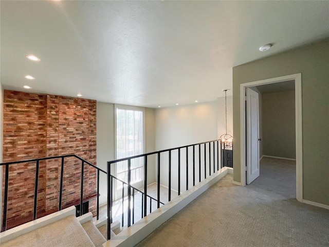 hallway with carpet floors and a chandelier