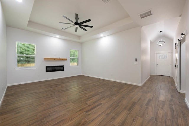 unfurnished living room featuring dark hardwood / wood-style floors, ceiling fan, and vaulted ceiling