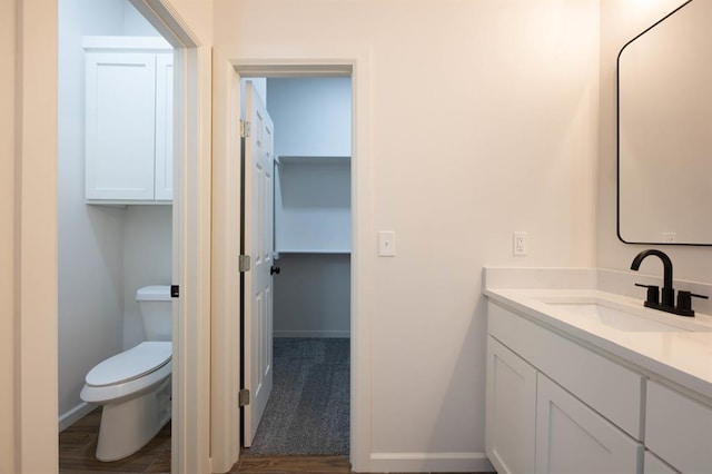 bathroom featuring hardwood / wood-style floors, vanity, and toilet