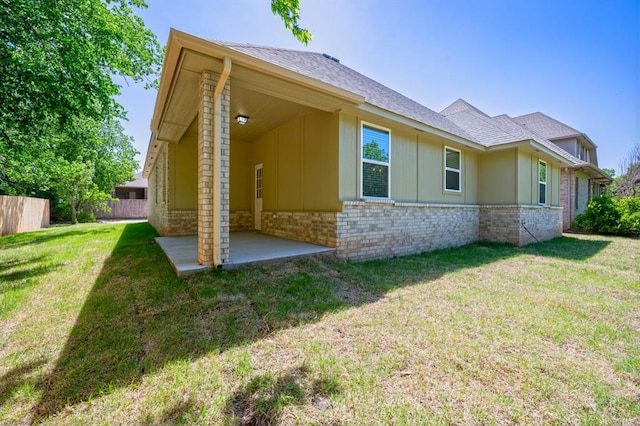 rear view of property featuring a patio area and a yard