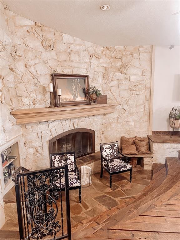 living area with a fireplace, a textured ceiling, and parquet flooring