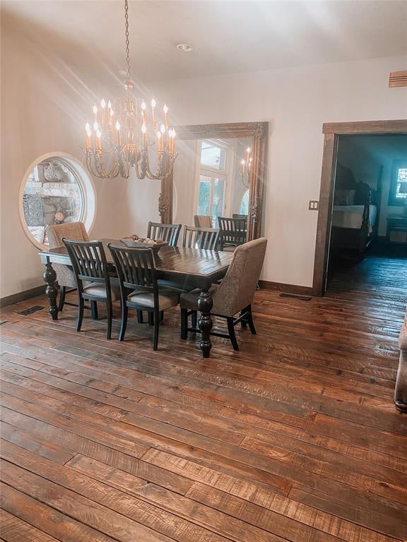 dining area with dark hardwood / wood-style floors and a notable chandelier