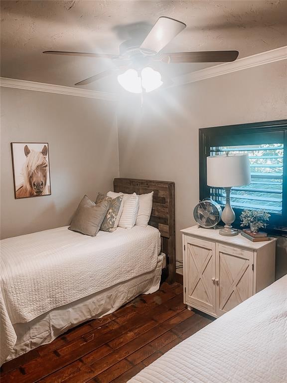 bedroom with ornamental molding, ceiling fan, and dark wood-type flooring