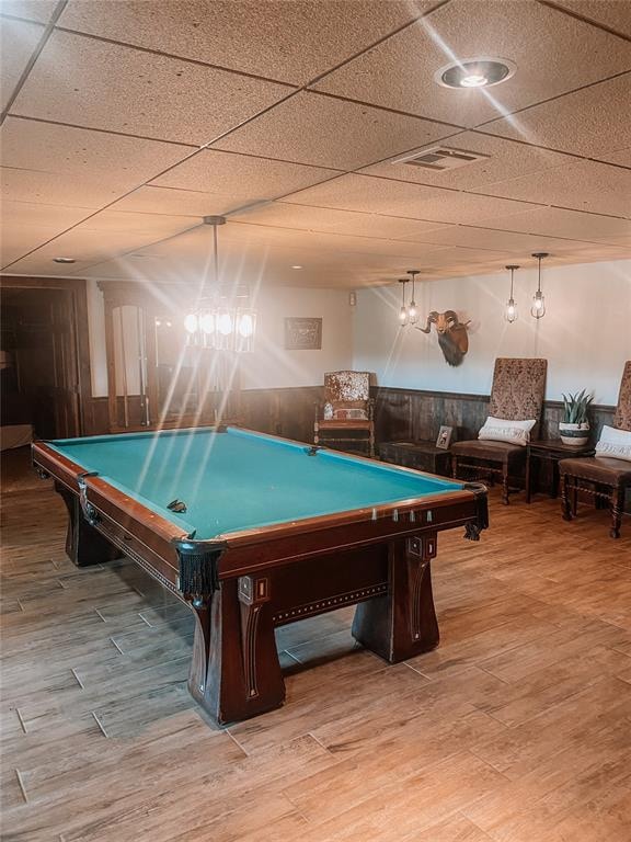 playroom featuring hardwood / wood-style flooring, a drop ceiling, wood walls, and pool table