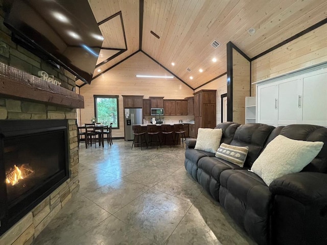 living room featuring wood walls, wood ceiling, a fireplace, and high vaulted ceiling