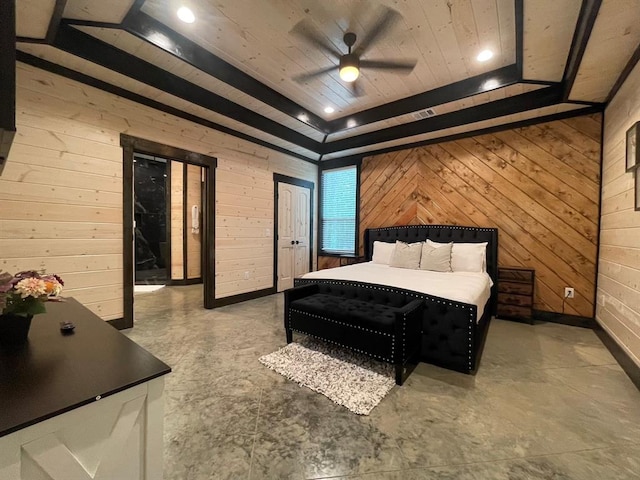 bedroom featuring ceiling fan, wood walls, and a raised ceiling