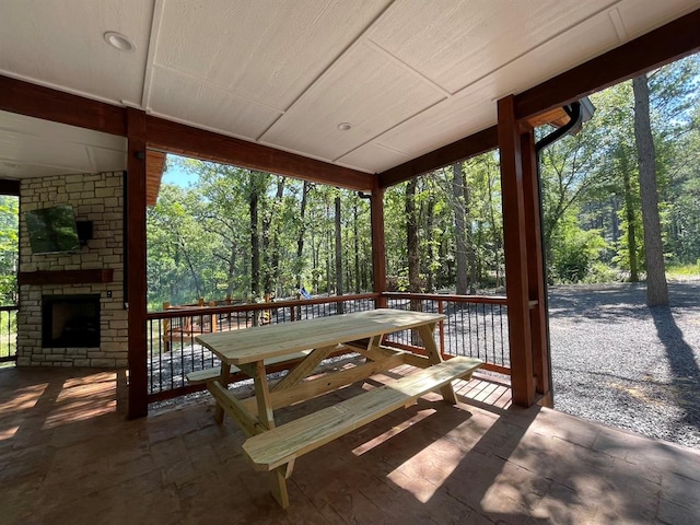 unfurnished sunroom with a wealth of natural light and an outdoor stone fireplace