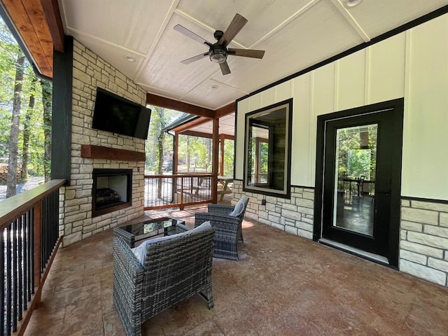 view of patio featuring an outdoor stone fireplace and ceiling fan