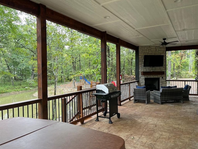 wooden terrace featuring an outdoor living space with a fireplace, a grill, and ceiling fan