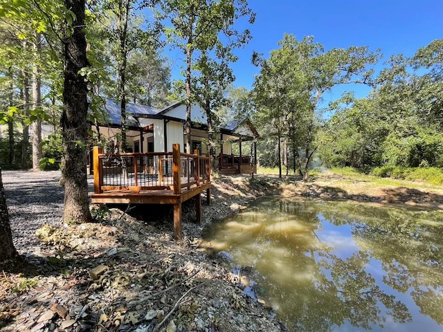 rear view of house with a deck with water view