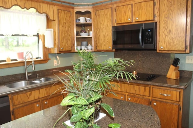 kitchen featuring dark stone countertops, dishwasher, sink, and decorative backsplash