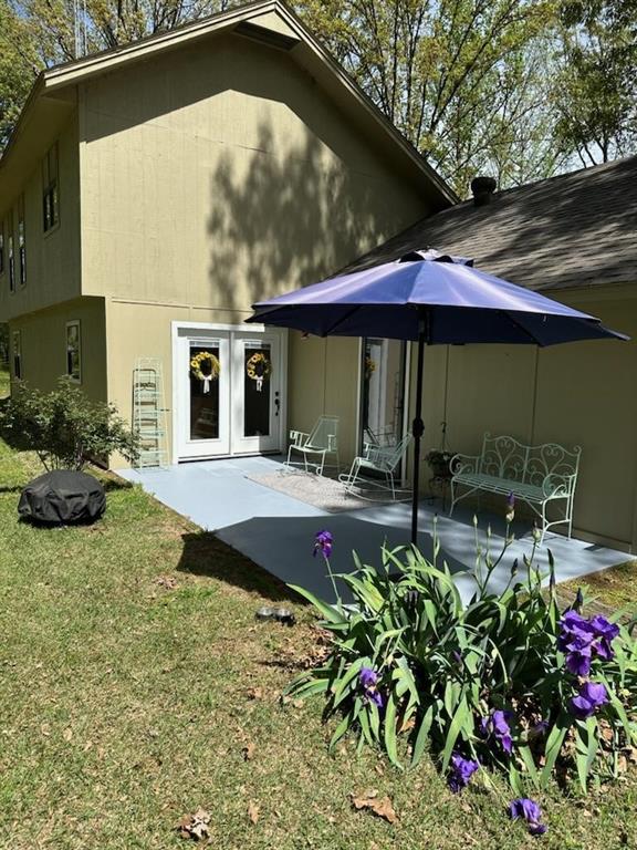 rear view of house with french doors, a patio, and a yard