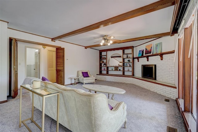 carpeted living room featuring beam ceiling, ceiling fan, and a brick fireplace