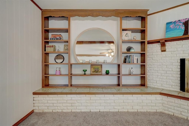 interior space with carpet floors, crown molding, and wood walls