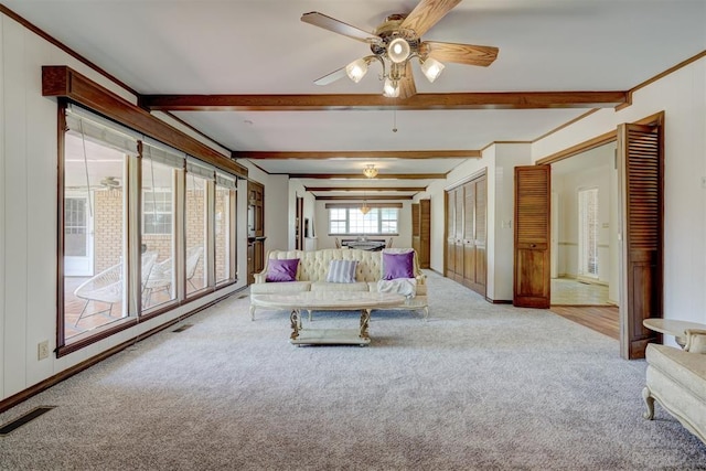 living room with beamed ceiling, light colored carpet, ceiling fan, and crown molding