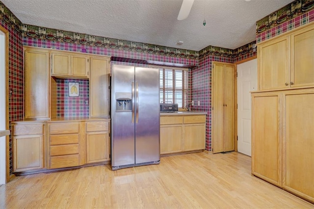 kitchen with stainless steel refrigerator with ice dispenser, light wood-type flooring, and light brown cabinets