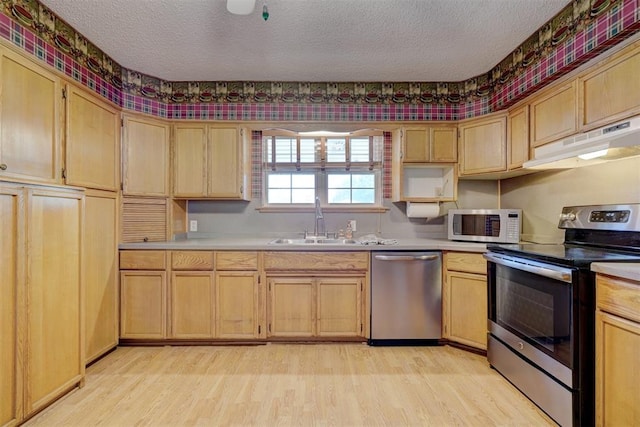 kitchen featuring a textured ceiling, stainless steel appliances, light hardwood / wood-style floors, and sink