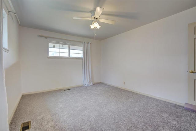 carpeted spare room featuring ceiling fan