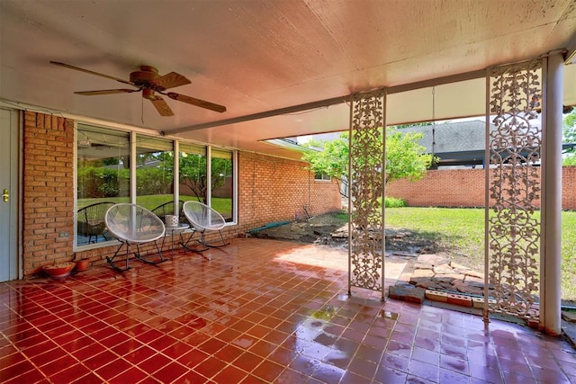 unfurnished sunroom with ceiling fan