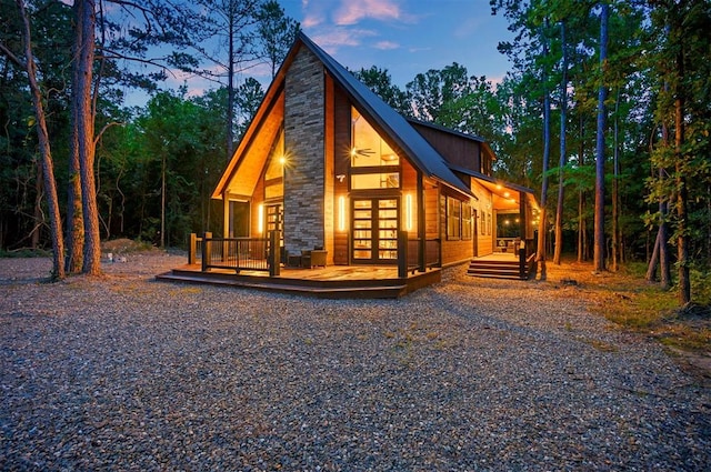 property exterior at dusk with a deck and french doors