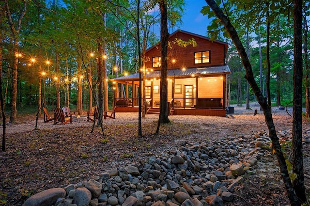 exterior space with covered porch and an outdoor fire pit