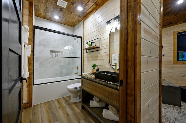 full bathroom featuring wood ceiling, enclosed tub / shower combo, hardwood / wood-style floors, wooden walls, and toilet