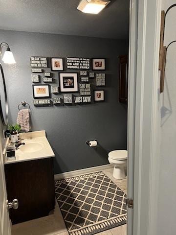 bathroom featuring tile patterned flooring, vanity, and toilet