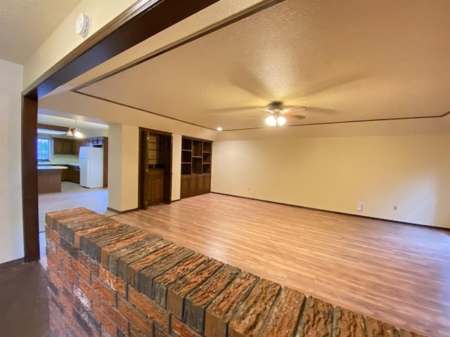 unfurnished room featuring ceiling fan, light hardwood / wood-style floors, and a textured ceiling