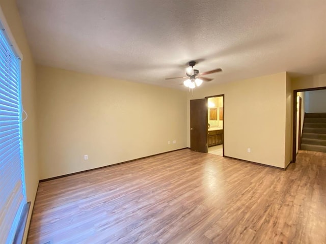 interior space featuring a textured ceiling, light wood-type flooring, and ceiling fan