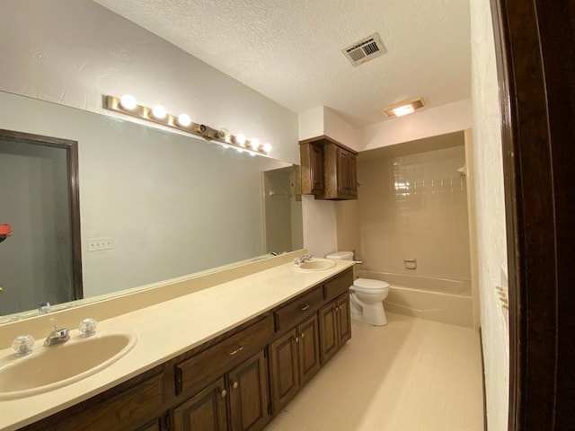 full bathroom featuring vanity, a textured ceiling, toilet, and tiled shower / bath