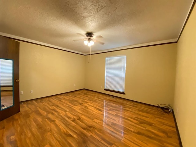 spare room featuring hardwood / wood-style floors, ceiling fan, ornamental molding, and a textured ceiling