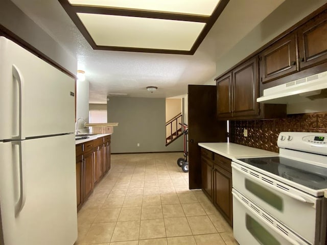 kitchen featuring backsplash, dark brown cabinets, white appliances, a textured ceiling, and light tile patterned floors