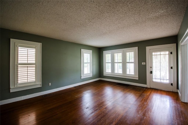 entrance foyer featuring a textured ceiling and dark hardwood / wood-style flooring