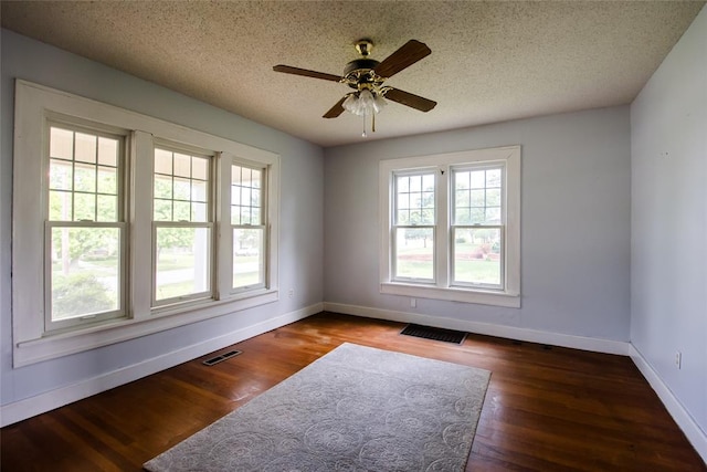 unfurnished room featuring a textured ceiling, dark hardwood / wood-style floors, and ceiling fan