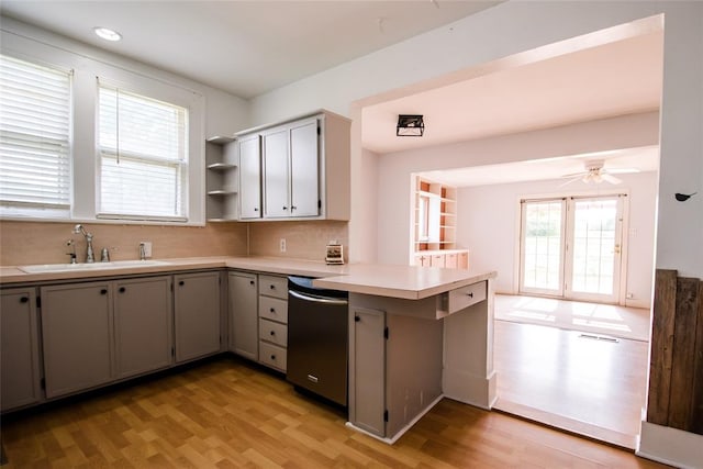 kitchen featuring gray cabinets, sink, stainless steel dishwasher, and light wood-type flooring