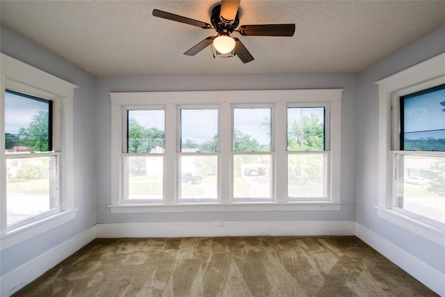 unfurnished sunroom with a wealth of natural light and ceiling fan