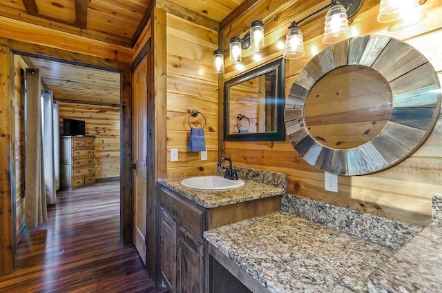 bathroom with hardwood / wood-style floors, vanity, wood walls, and wood ceiling