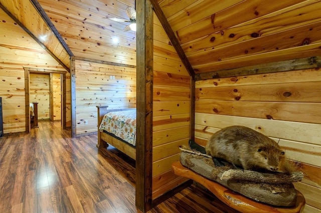 bedroom with dark hardwood / wood-style flooring, wooden ceiling, wooden walls, and vaulted ceiling