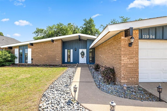 entrance to property featuring a lawn and a garage