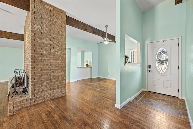 entryway with ceiling fan, beamed ceiling, and dark wood-type flooring