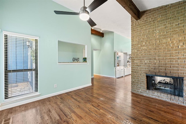 unfurnished living room featuring high vaulted ceiling, a brick fireplace, hardwood / wood-style flooring, ceiling fan, and beam ceiling