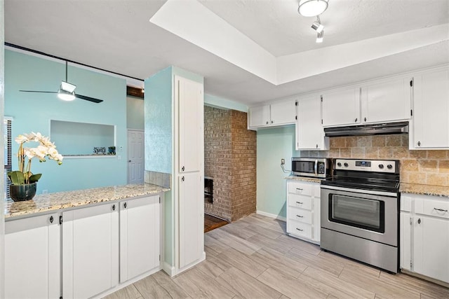 kitchen with white cabinets, appliances with stainless steel finishes, light hardwood / wood-style flooring, and light stone counters