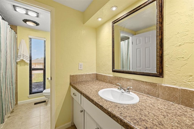 bathroom featuring tile patterned flooring, vanity, and toilet