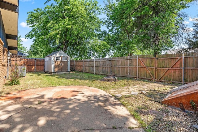 view of yard with a patio area, a storage unit, and an outdoor fire pit